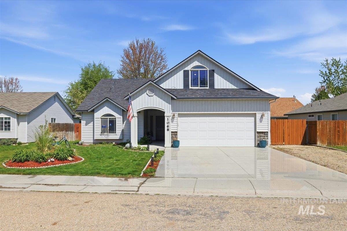 Single-story residence featuring light-colored siding, a dark shingle roof, and an attached two-car garage