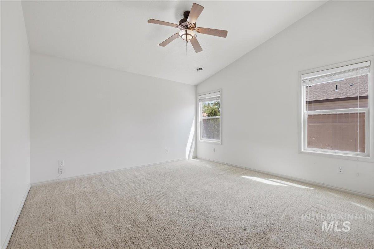 1068 Locksley Street Middleton, ID 83644 - Photo 18 of 30 Carpeted room with a vaulted ceiling, two windows with blinds, and a ceiling fan