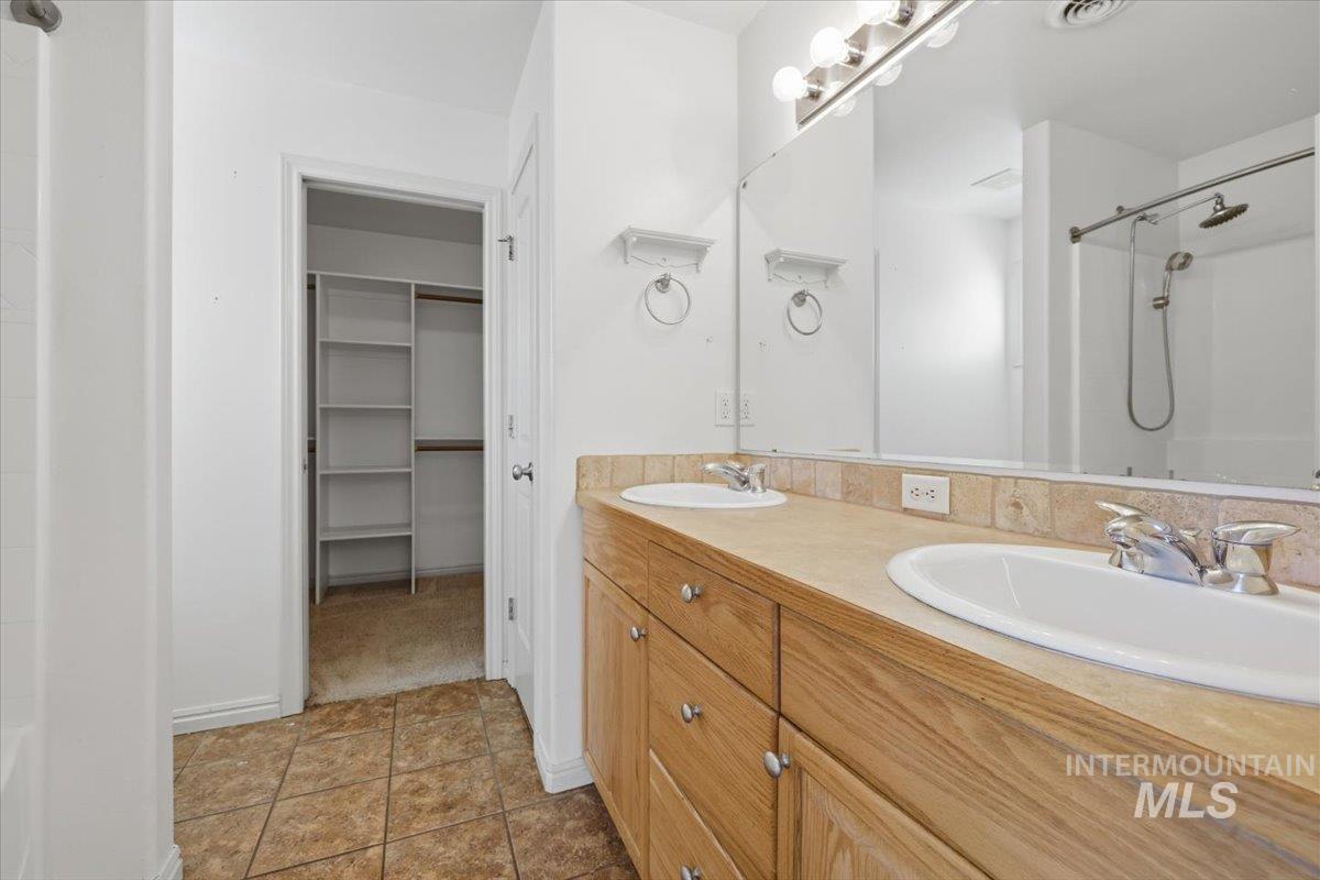 1068 Locksley Street Middleton, ID 83644 - Photo 20 of 30 Bathroom featuring a double vanity with wood-finish cabinetry, dual sinks, and a large mirror