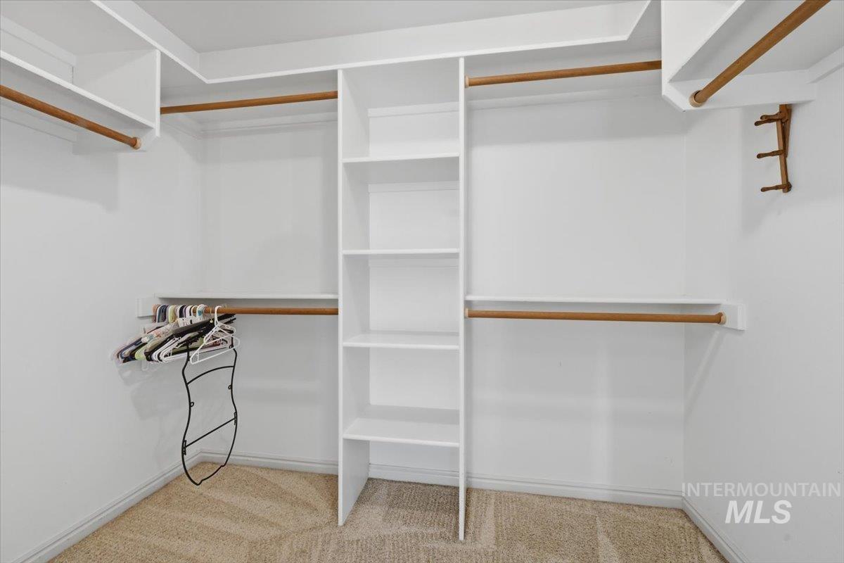 1068 Locksley Street Middleton, ID 83644 - Photo 21 of 30 Walk-in closet featuring built-in shelving, multiple hanging rods, and neutral carpet flooring
