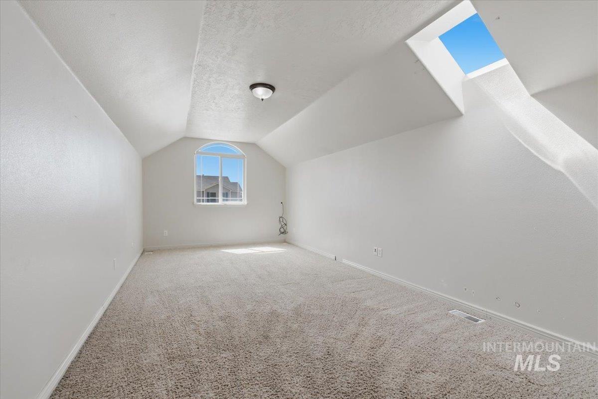 1068 Locksley Street Middleton, ID 83644 - Photo 22 of 30 Attic bonus room featuring a window with an arched transom, a skylight, and neutral carpeting