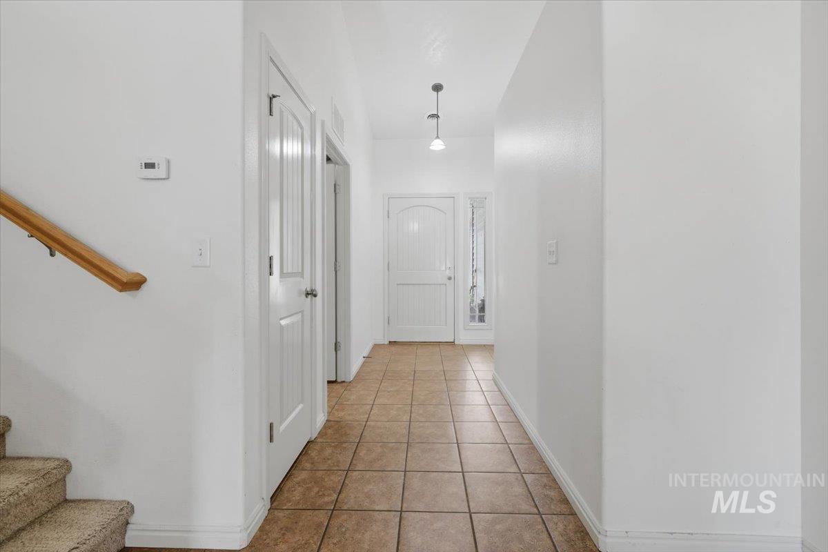 1068 Locksley Street Middleton, ID 83644 - Photo 4 of 30 Entryway featuring ceramic tile flooring, a paneled front door with sidelight, and pendant lighting
