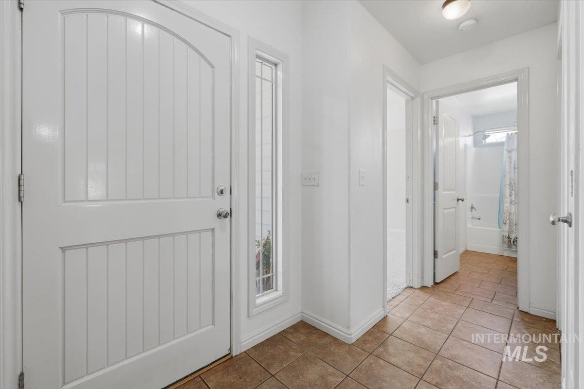1068 Locksley Street Middleton, ID 83644 - Photo 5 of 30 Entryway featuring a white paneled door with an arched top, a sidelight window with decorative muntins, and tiled flooring