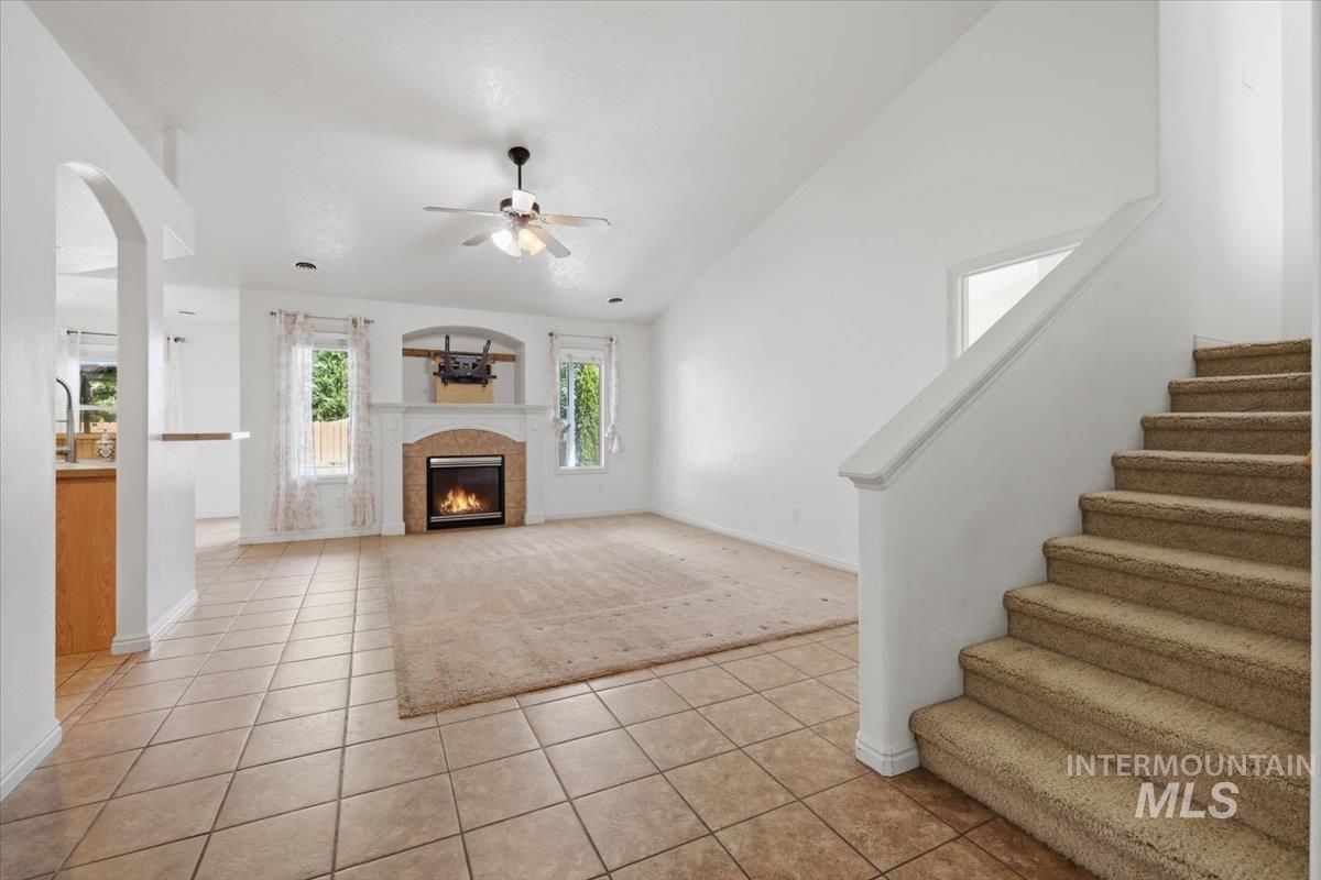 1068 Locksley Street Middleton, ID 83644 - Photo 6 of 30 Spacious living area featuring a fireplace with a stone surround, a ceiling fan, and tile flooring