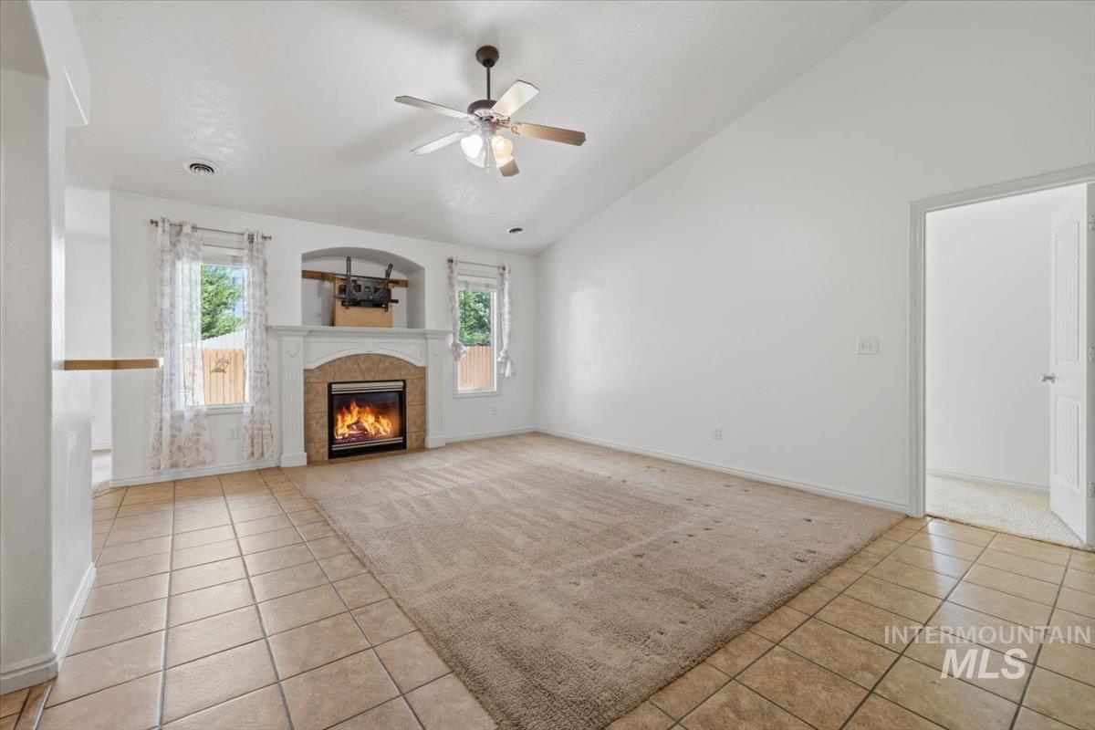 1068 Locksley Street Middleton, ID 83644 - Photo 7 of 30 Living area featuring a fireplace with an arched stone surround and a detailed white mantel