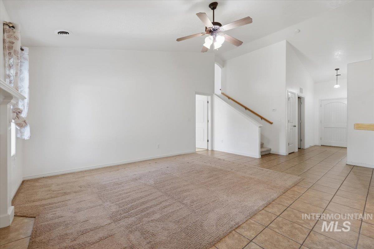 1068 Locksley Street Middleton, ID 83644 - Photo 8 of 30 Spacious living area featuring a large carpeted section, tile flooring, and a ceiling fan with integrated lighting