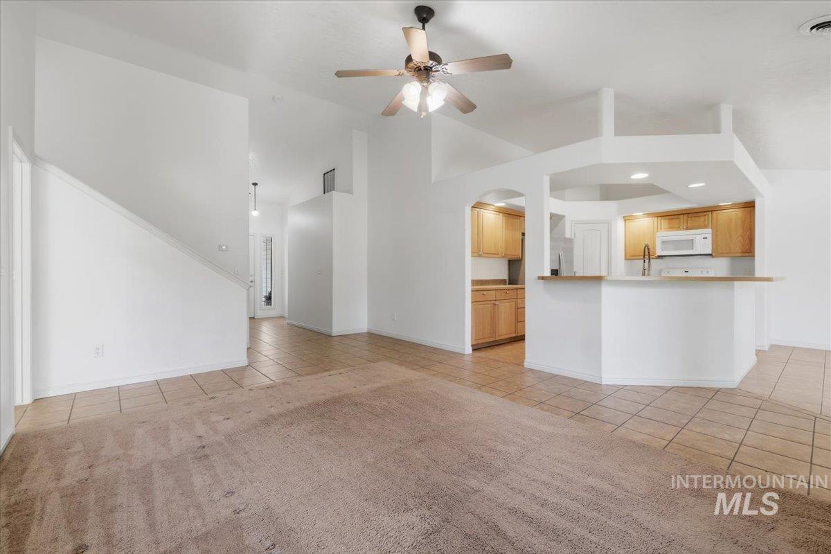 1068 Locksley Street Middleton, ID 83644 - Photo 9 of 30 Open-concept living space with vaulted ceilings, a ceiling fan, and tile flooring