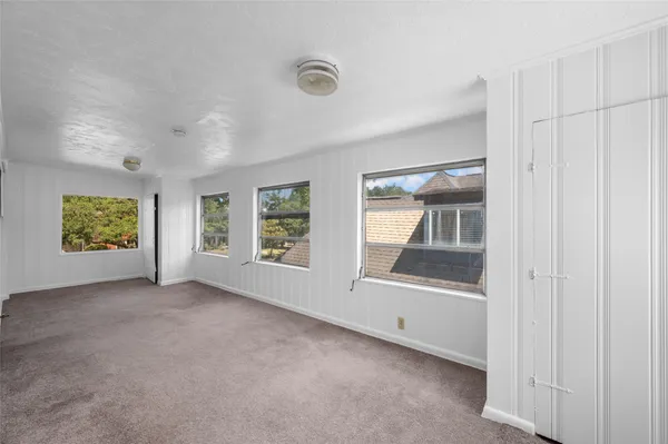 an empty room with windows and closet