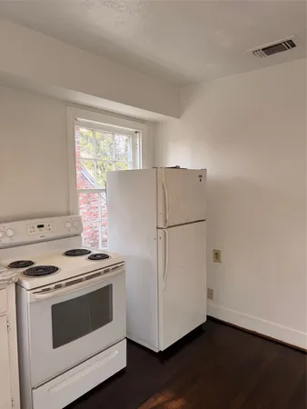 a white refrigerator freezer and a stove sitting inside of a kitchen