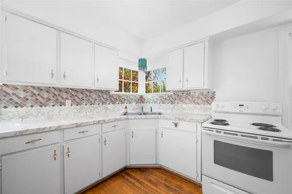 a kitchen with granite countertop white cabinets and white appliances