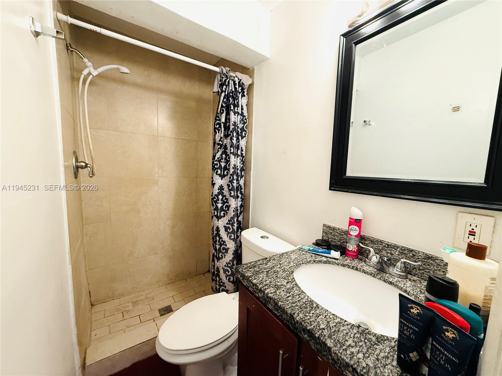 635 Northwest 22nd Road Fort Lauderdale, FL 33311 - Photo 14 of 20 a bathroom with a granite countertop sink toilet mirror and a shower