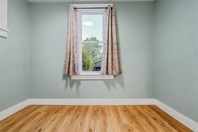 a view of a room with wooden floor and small window