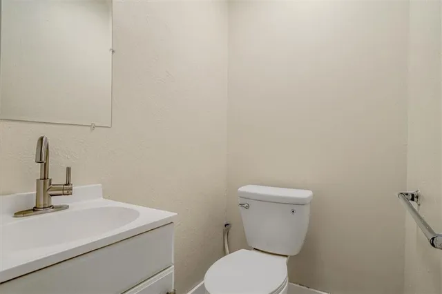 a bathroom with a toilet a sink and mirror