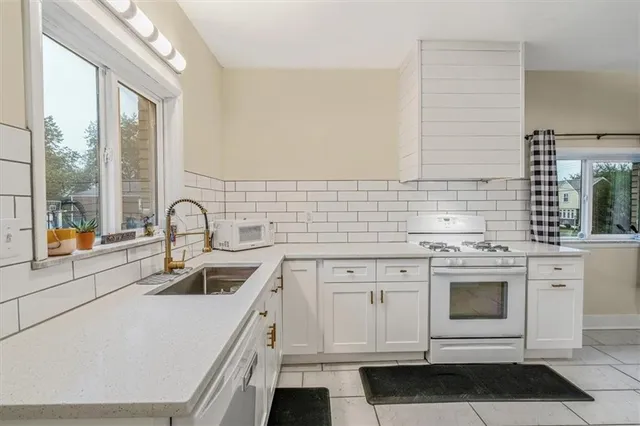 a kitchen with stainless steel appliances a stove sink and cabinets