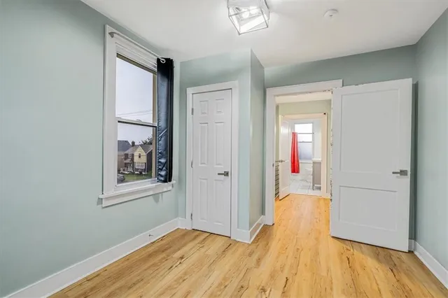an empty room with wooden floor and closet