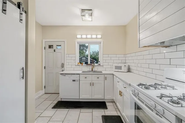 a kitchen with granite countertop white cabinets and appliances