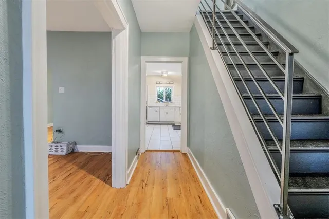 a view of a hallway with wooden floor and staircase