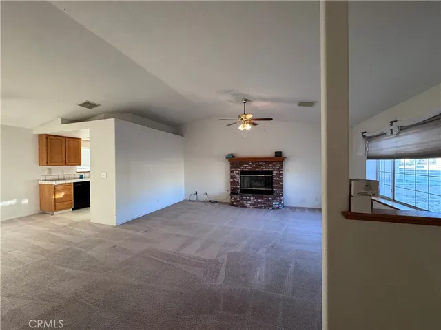 a view of an empty room with a fireplace and a window
