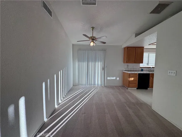 a view of a livingroom with a fireplace a ceiling fan and wooden floor