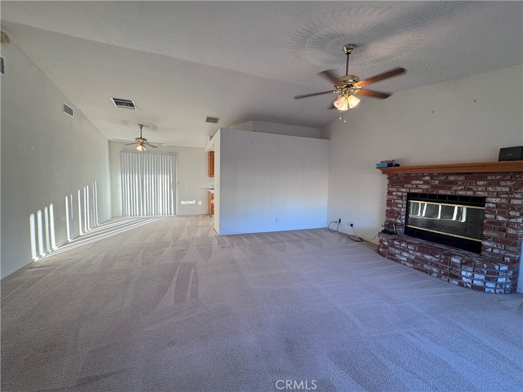 400 Vista Street Ridgecrest, CA 93555 - Photo 14 of 32 a view of a livingroom with a fireplace a ceiling fan and wooden floor