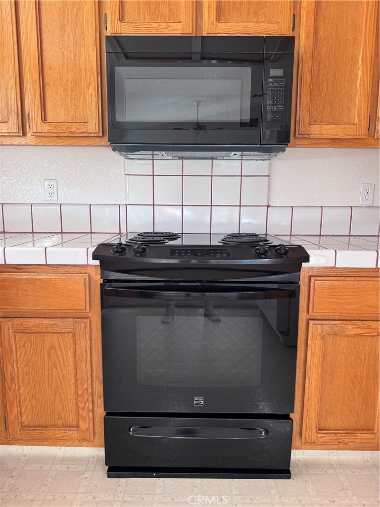 400 Vista Street Ridgecrest, CA 93555 - Photo 16 of 32 a kitchen with granite countertop cabinets and black stainless steel appliances