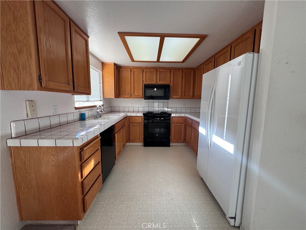 400 Vista Street Ridgecrest, CA 93555 - Photo 18 of 32 a kitchen with stainless steel appliances granite countertop a stove a refrigerator and a sink