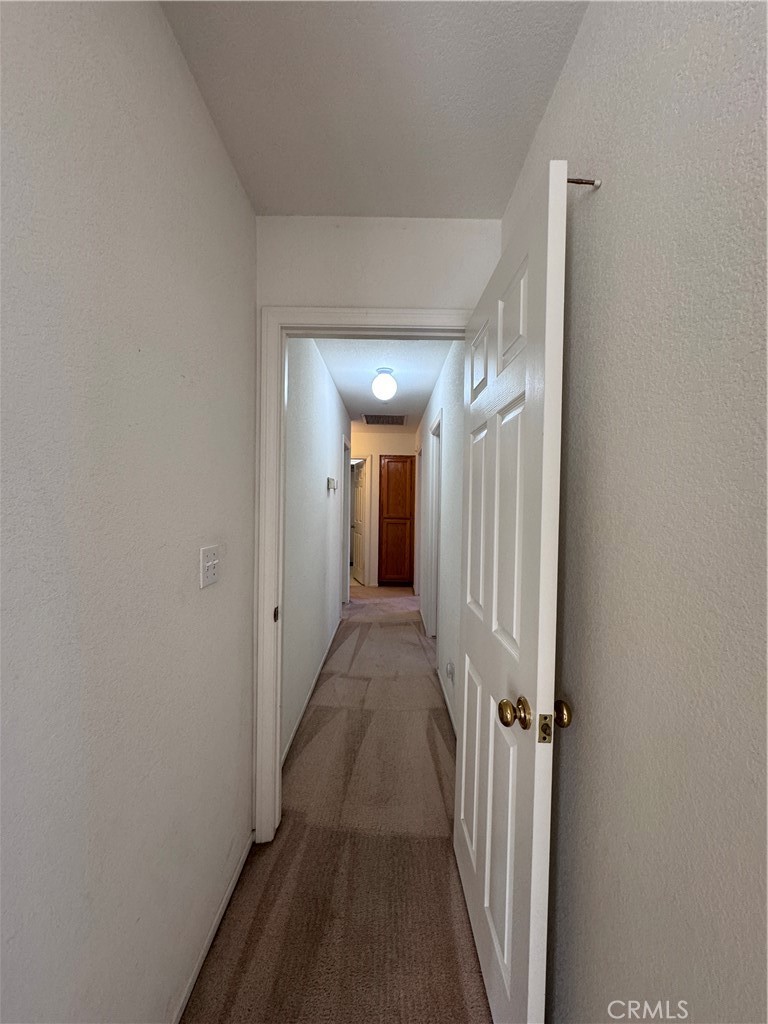400 Vista Street Ridgecrest, CA 93555 - Photo 20 of 32 a view of a hallway with wooden floor and a bathroom