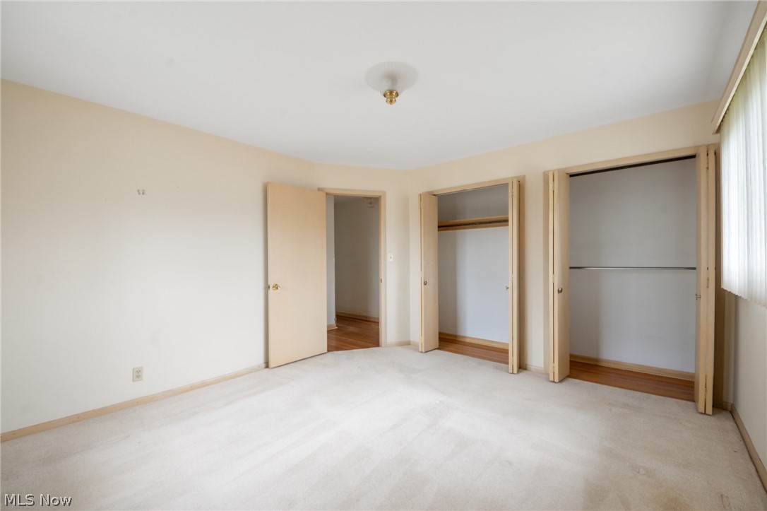 28879 Ridge Road Wickliffe, OH 44092 - Photo 14 of 34 Unfurnished bedroom featuring two closets and light colored carpet