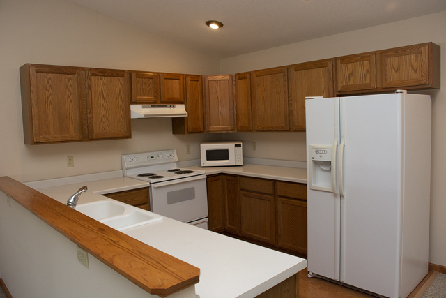 15479 Henry Road, Unit B Morrison, IL 61270 - Photo 8 of 18 a kitchen with stainless steel appliances a stove a refrigerator and a sink with wooden cabinets