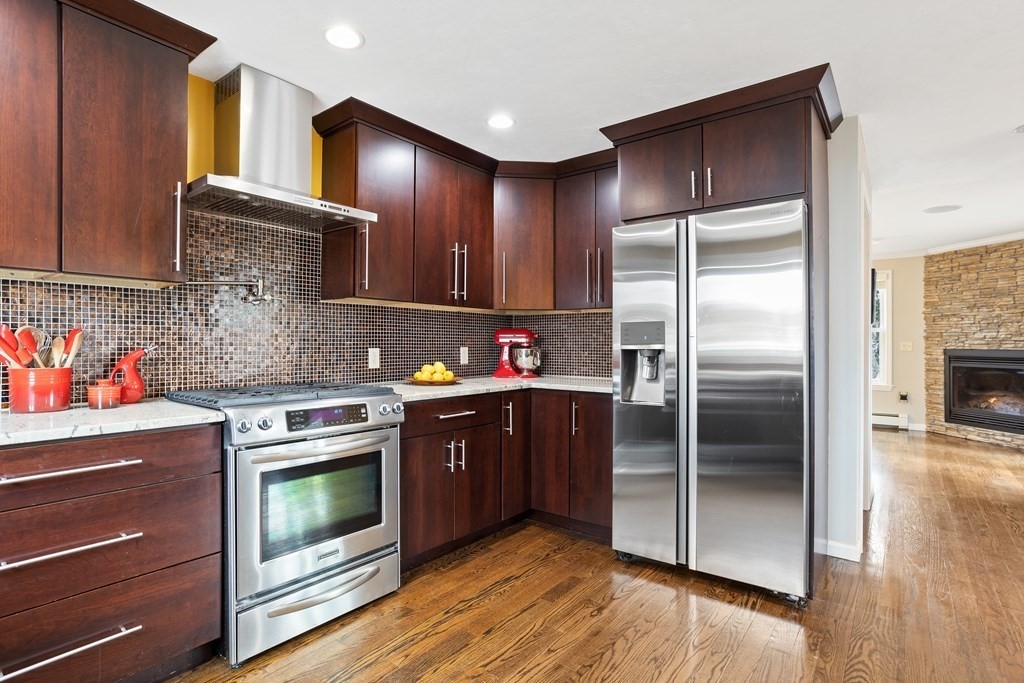 114 River Street Hudson, MA 01749 - Photo 10 of 40 a kitchen with stainless steel appliances granite countertop a refrigerator a stove and a wooden floors