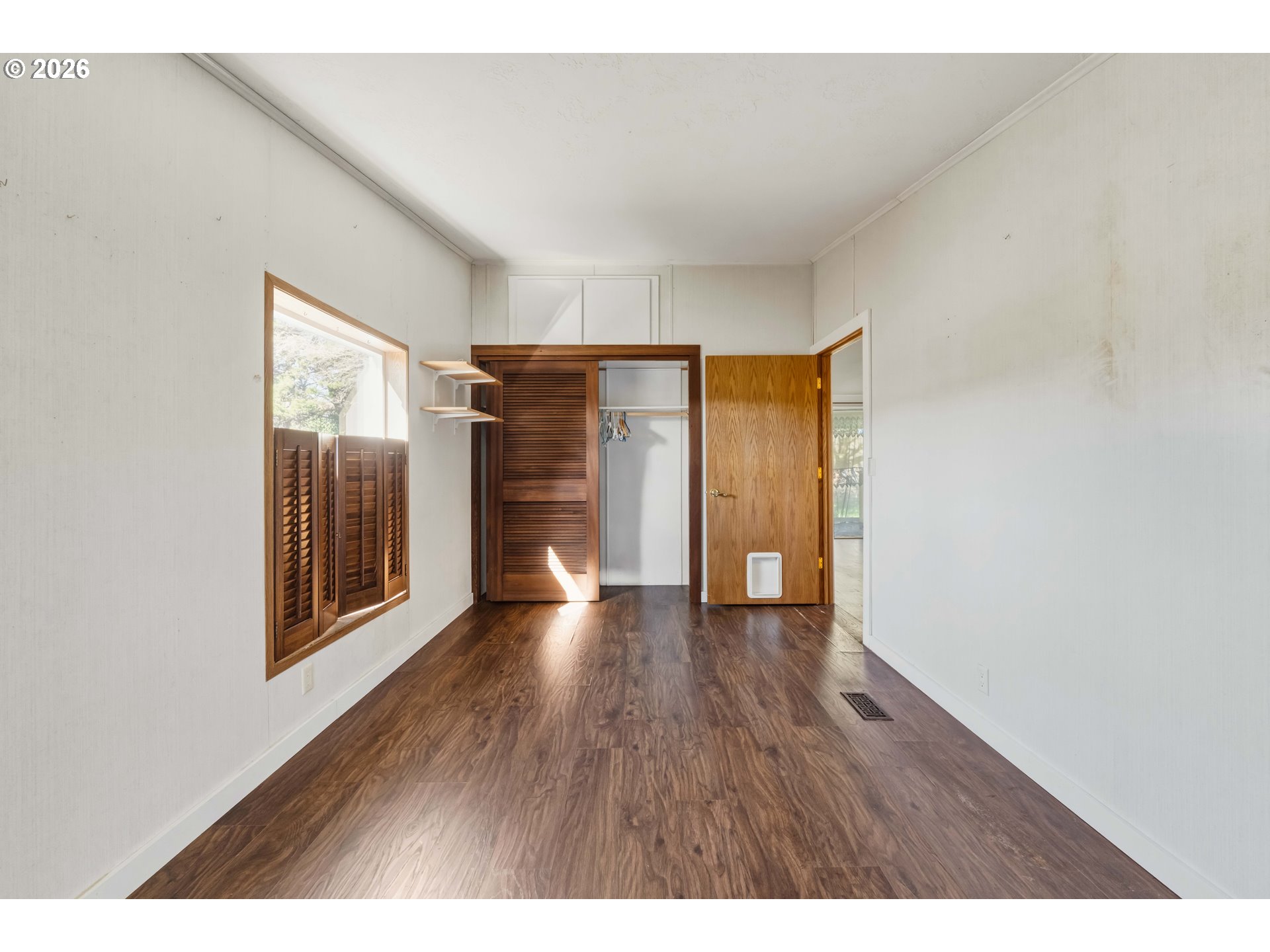 1030 June Avenue Southeast Bandon, OR 97411 - Photo 12 of 43 a view of an empty room with wooden floor and a window