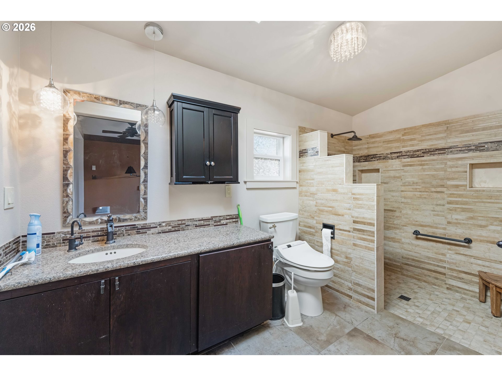 1030 June Avenue Southeast Bandon, OR 97411 - Photo 16 of 43 a bathroom with a granite countertop toilet sink and mirror