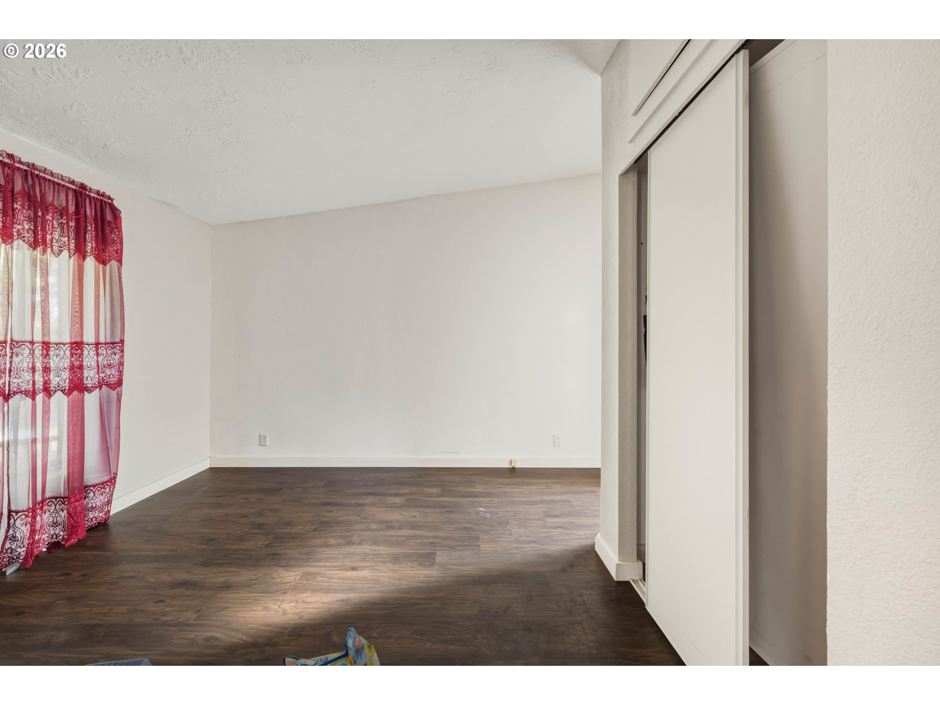 1030 June Avenue Southeast Bandon, OR 97411 - Photo 19 of 43 a view of an empty room with wooden floor and a window