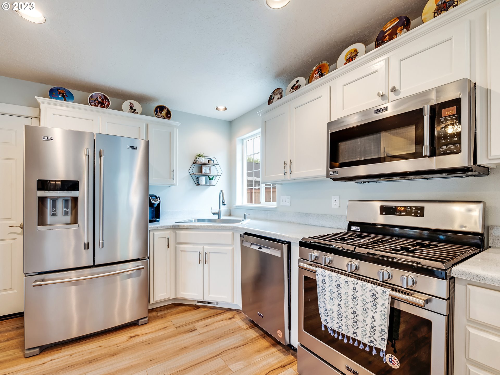 939 65th Place Springfield, OR 97478 - Photo 10 of 36 a kitchen with stainless steel appliances white cabinets a stove a microwave and a refrigerator