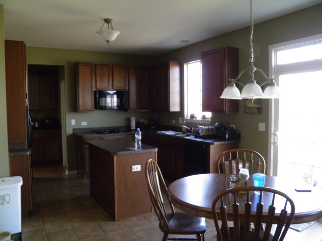 3090 Patterson Road Montgomery, IL 60538 - Photo 10 of 14 a kitchen with granite countertop stainless steel appliances a dining table and chairs