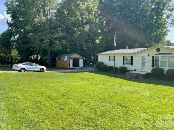 a front view of a house with a garden and trees