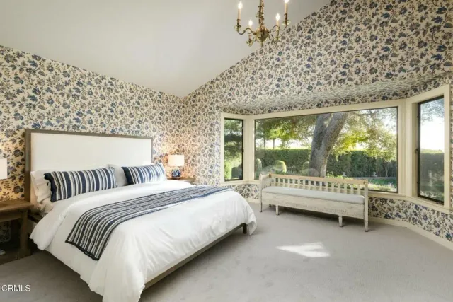 a bedroom with a bed and a large window with outer view