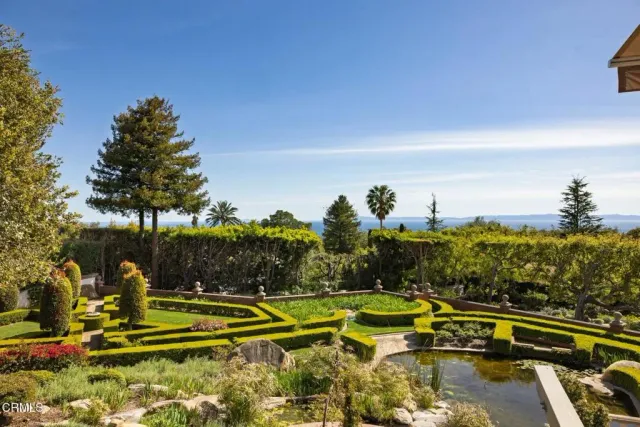 a view of swimming pool with outdoor seating and trees in the background