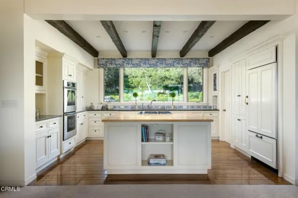 a large white kitchen with a large window