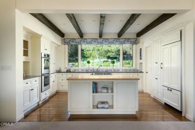 a large white kitchen with a large window