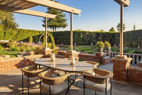 a view of an outdoor dining space with a table and chairs