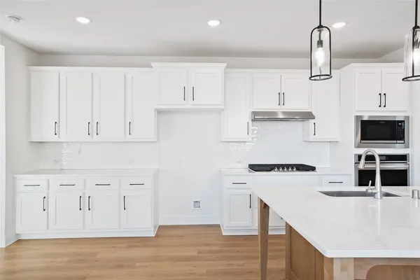 a kitchen with stainless steel appliances granite countertop a sink a stove and a refrigerator