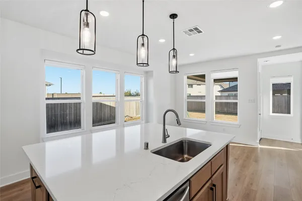 a kitchen with stainless steel appliances granite countertop a sink a stove and a refrigerator