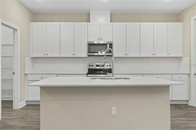 a kitchen with white cabinets and stainless steel appliances
