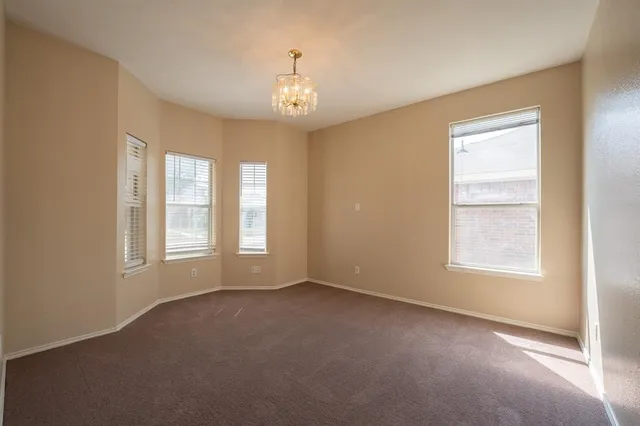 an empty room with a window and ceiling fan