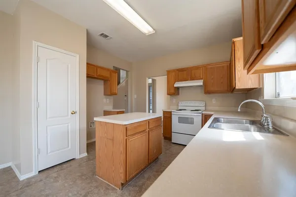 a kitchen with a stove sink and cabinets