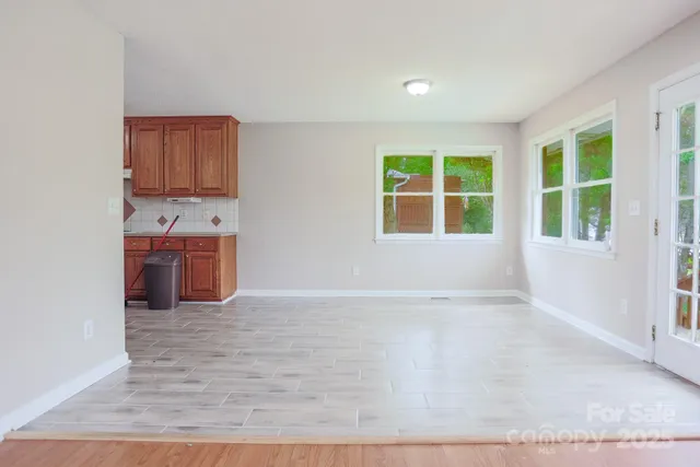 an empty room with wooden floor and cabinet