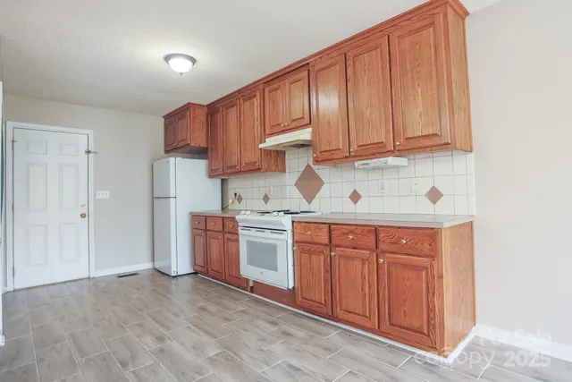 a kitchen with stainless steel appliances granite countertop a refrigerator sink and cabinets