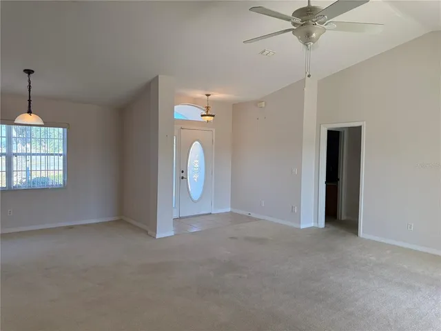 en empty room with windows and fan