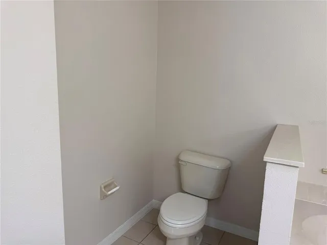 a white toilet sitting next to a white cabinet
